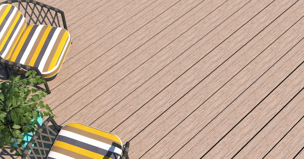 A wide shot of a deck made of composite boards. There are two striped chairs and a potted plant on the deck.